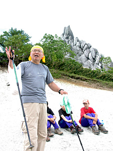 鳳凰三山・地蔵ケ岳山頂のオベリスクの前で南アルプスの歴史や魅力を伝える清水准一さん