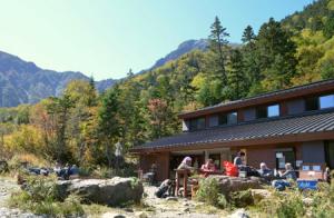 登山者でにぎわう白根御池小屋。小屋の周辺では、ナナカマドやダケカンバの木々の葉が赤や黄色に色づいている