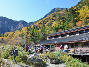 登山客でにぎわう白根御池小屋。周囲の木々は色づき、多くの登山客が写真を撮るなどして紅葉を楽しんでいた