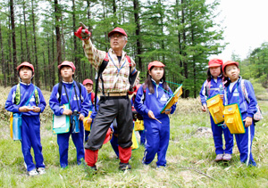 地元の小学生を案内し、景観の特徴を教える甘利山倶楽部の市川秀明さん=韮崎・甘利山