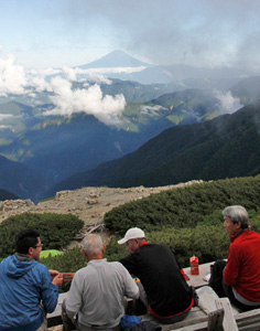 <眺望> 富士山を眺めながら食事をとる登山者。国内最高峰を望む絶景は、疲れ切った体を癒やしてくれる