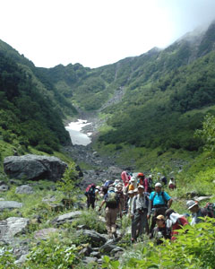 登山者：北岳を目指して大樺沢の登山道を登る登山者。奥には雪渓が見える（写真左）