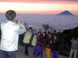 富士山の朝焼けをバックに記念撮影する人々